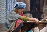 Seorang penenun perempuan di Sumba sedang merangkai benang bermotif tradisional dengan menggunakan teknik pewarnaan alami yang diwariskan secara turun-temurun.