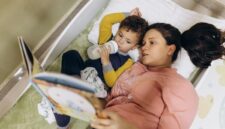 Seorang ibu membacakan buku cerita rakyat bergambar kepada anaknya sebelum tidur untuk membangun ikatan emosional dan mengenalkan kebudayaan Nusantara sejak dini.